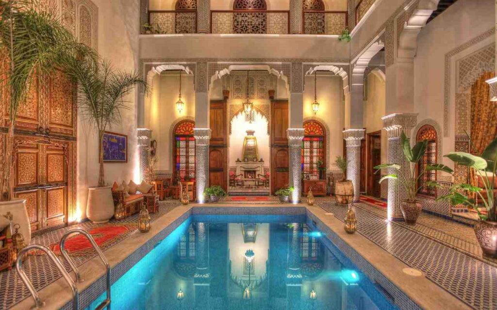 An indoor pool surrounded by pillars and stained glass windows.
