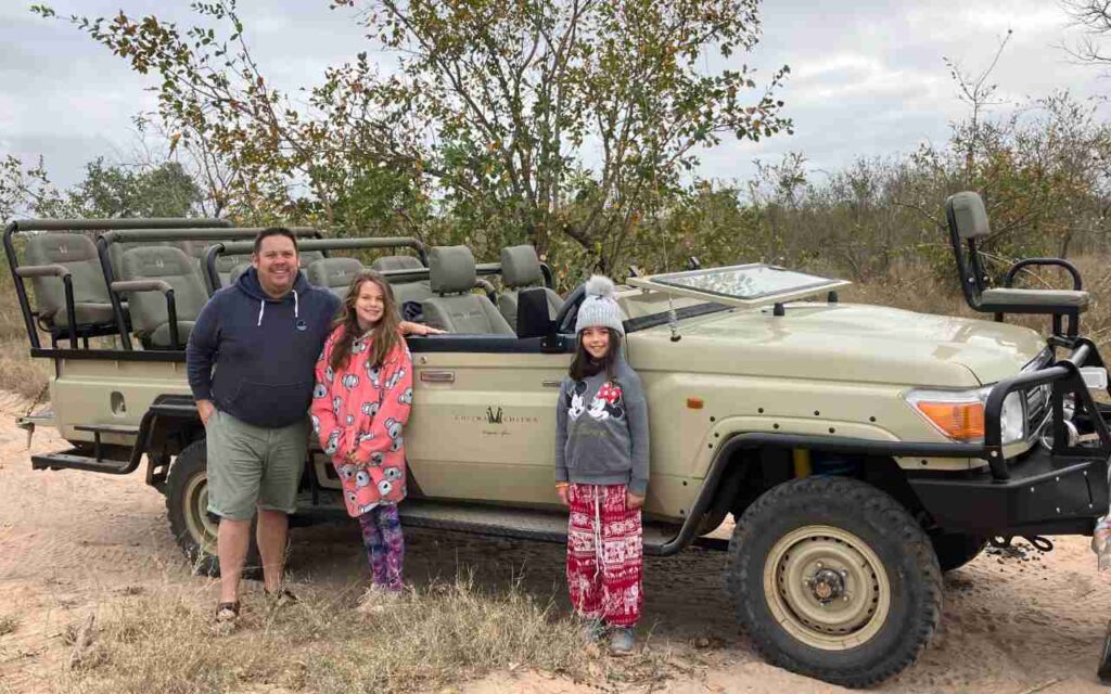 Steve, the owner, with his daughters standing in front of their safari vehicle