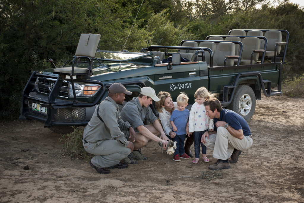 A family on a game drive interacting with guides on a private family safari.